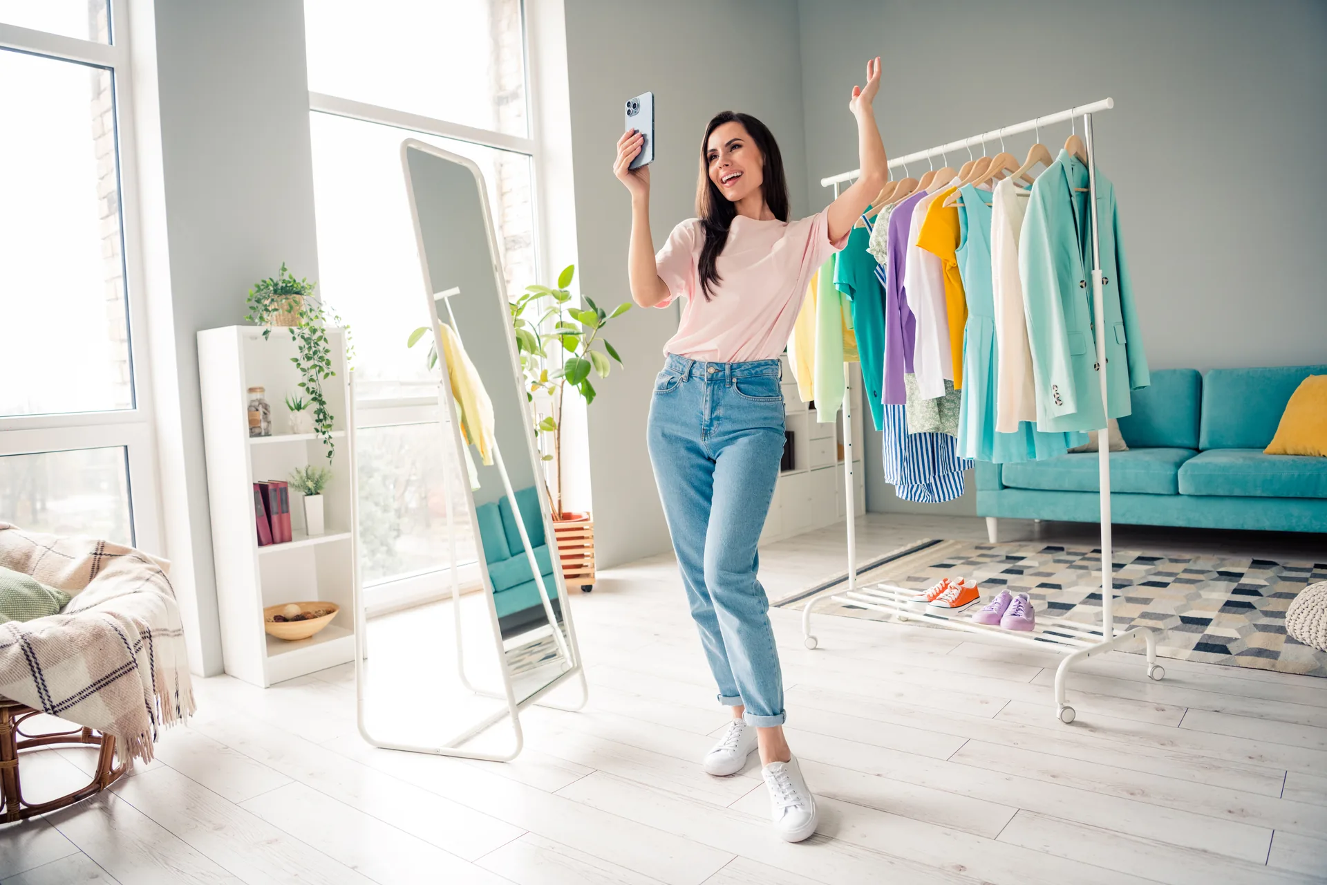 Woman taking a mirror selfie near a clothing rack